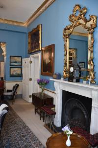 a living room with a fireplace and a mirror at The Cranley Hotel in London