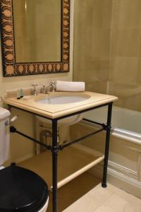 a bathroom with a sink and a bath tub at The Cranley Hotel in London