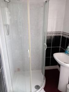 um chuveiro com uma porta de vidro ao lado de um lavatório em Aberdeen Arms Hotel Tarland em Tarland