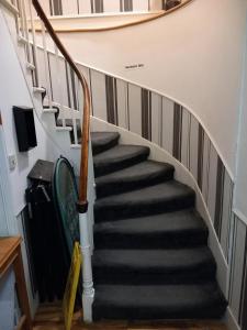 a staircase in a house with black and white stairs at Aberdeen Arms Hotel Tarland in Tarland