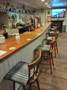 szereg krzeseł w barze w restauracji w obiekcie Aberdeen Arms Hotel Tarland w mieście Tarland