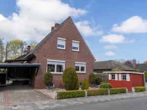 a brick house with a red garage at 190 Feriendomizil Nordlicht in Wilhelmshaven +24 photos