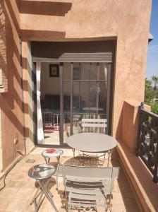 a patio with a table and chairs on a balcony at Appart atlas resort in Marrakesh