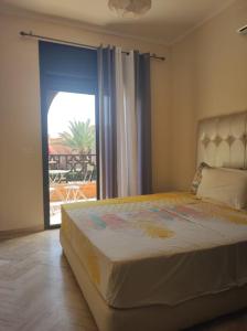 a bedroom with a bed and a sliding glass door at Appart atlas resort in Marrakesh +11 photos