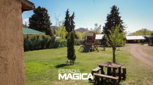 a picnic table in a field with trees and a building at Cabañas en Valle de Uco in Tunuyán