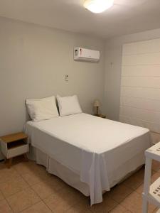 - une chambre dotée d'un grand lit avec des draps et des oreillers blancs dans l'établissement Apartamento no Aquaville Resort, do lado da sombra e perto da praia, à Aquiraz
