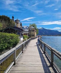 a person walking on a bridge over a body of water at See- und Bergblick in Bestlage am Tegernsee in Tegernsee