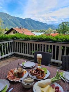 a table with plates of food on a deck at See- und Bergblick in Bestlage am Tegernsee in Tegernsee