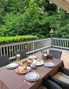 un tavolo in legno con piatti di cibo su una terrazza di See- und Bergblick in Bestlage am Tegernsee a Tegernsee