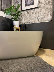 a white bath tub in a bathroom with a plant at See- und Bergblick in Bestlage am Tegernsee in Tegernsee