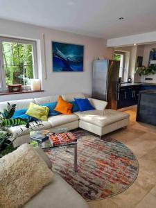 ein Wohnzimmer mit einem Sofa und einem Tisch in der Unterkunft See- und Bergblick in Bestlage am Tegernsee in Tegernsee