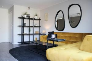 - un salon avec un canapé jaune et un miroir dans l'établissement HOLTINGERHUYS Uffelte- Giethoorn! Optie Wellness!!!, à Uffelte