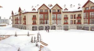 a large building with snow in front of it at 2B Gudauri Apartments in Gudauri
