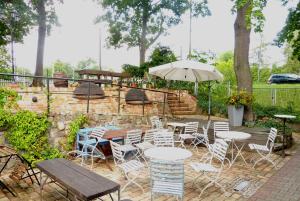 a patio with tables and chairs and an umbrella at FeWo im Sahneröschen in Magdeburg