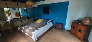 a bedroom with a bed and a blue wall at Appartement de charme à côté de la plage in La Saline les Bains