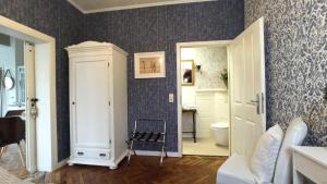 a bathroom with a toilet and a chair in a room at FeWo im Sahneröschen in Magdeburg