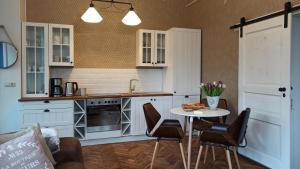a kitchen with white cabinets and a table and chairs at FeWo im Sahneröschen in Magdeburg