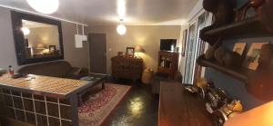 a living room with a couch and a mirror at Appartement de charme à côté de la plage in La Saline les Bains