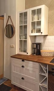 a kitchen with white cabinets and a mirror at FeWo im Sahneröschen in Magdeburg +11 photos