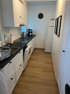 a kitchen with white cabinets and black counter tops at Cosy apartment in the heart of Lahti, free parking in Lahti