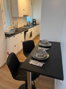 a kitchen with a black table and black chairs at Cosy apartment in the heart of Lahti, free parking in Lahti