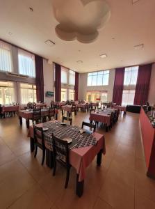 una sala da pranzo con tavoli, sedie e finestre di Hotel Pórtico Norte a Tartagal