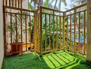 a room with a balcony with green grass at Rosean Homestay Self Service Apartments in Candolim