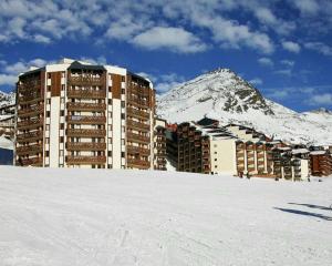 a building in the snow in front of a mountain at Cosy Val Tho ski aux pieds in Val Thorens