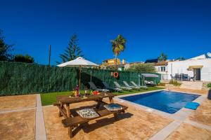 アルクーディアにあるIdeal Property Mallorca - Can Micaloの裏庭(テーブル、パラソル、プール付)