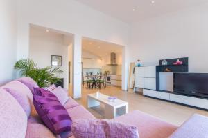 アルクーディアにあるIdeal Property Mallorca - Can Micaloのリビングルーム(紫色のソファ、テレビ付)