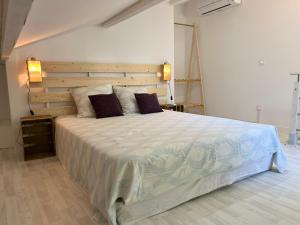 a bedroom with a large bed with a wooden headboard at Cabanon contemporain - Côte bleue - Calanque de la Redonne in Ensuès-la-Redonne