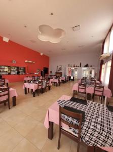 a restaurant with tables and chairs and pink walls at Hotel Pórtico Norte in Tartagal