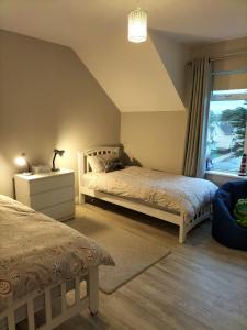 a bedroom with two beds and a window at Dolmen Apartment Carlingford Lough,Omeath in Ó Méith