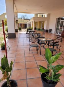 a patio with tables and chairs and plants at Hotel Pórtico Norte in Tartagal