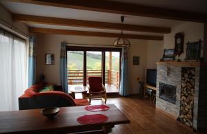 a living room with a table and a fireplace at Chata Dáša in Vyšný Kubín