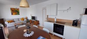 uma cozinha e sala de estar com uma mesa e um sofá em Gites Puy Mary et Puy Griou em Saint-Cernin
