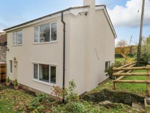 une maison blanche avec une clôture devant elle dans l'établissement Pool House, à Monmouth