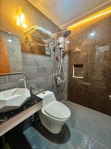a bathroom with a toilet and a sink and a shower at Sky Traveller Suites in Panglao Island