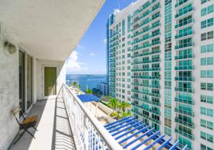 a balcony with blue chairs and a tall building at 2BD Condo At Brickell With Bay View in Miami