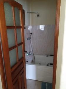 y baño con bañera y ducha. en Casa Alegre en São Filipe