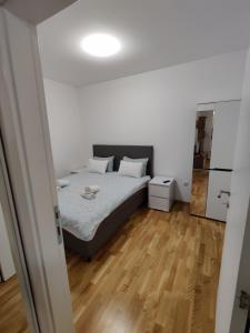 een slaapkamer met een bed en een houten vloer bij Citadela apartment Novi Sad in Petrovaradin