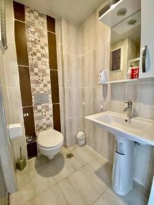 La salle de bains est pourvue de toilettes et d'un lavabo. dans l'établissement Palmiye Gold, à Çiftlikköy