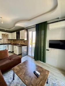 ein Wohnzimmer mit einem Sofa und einem Tisch in der Unterkunft Palmiye Gold in Çiftlikköy