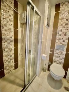 La salle de bains est pourvue d'une douche et de toilettes. dans l'établissement Palmiye Gold, à Çiftlikköy