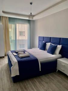 a bedroom with a blue bed with a blue headboard at Palmiye Gold in Çiftlikköy
