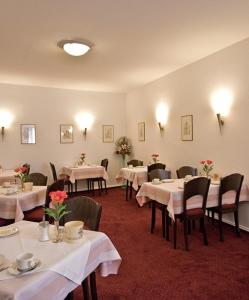 ein Esszimmer mit Tischen und Stühlen sowie weißen Tischdecken in der Unterkunft Hotel Bären in Villingen-Schwenningen
