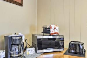 a microwave sitting on top of a counter next to a coffee maker at Cozy Hawkinsville Studio on Operating Farm! in Hawkinsville