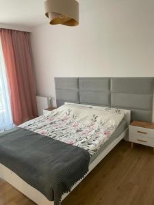 um quarto com uma cama com uma cabeceira cinzenta em The Botanic Corner Apartment em Breslávia