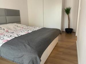 a bedroom with a bed and a potted plant at The Botanic Corner Apartment in Wrocław