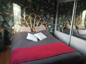 a bedroom with a large bed with a red blanket at LA PETITE MEUNIERE 